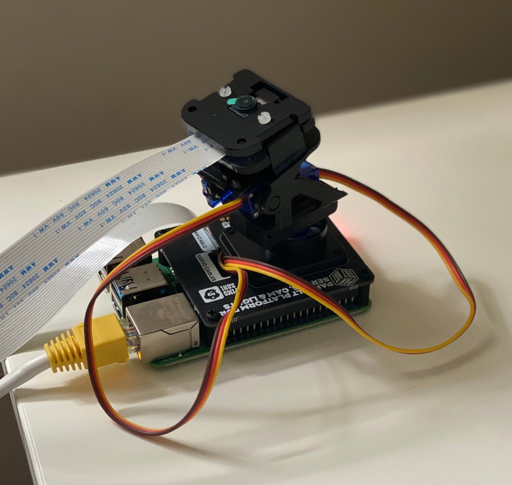 A Raspberry Pi 4 with an assembled pan-tilt hat and camera.